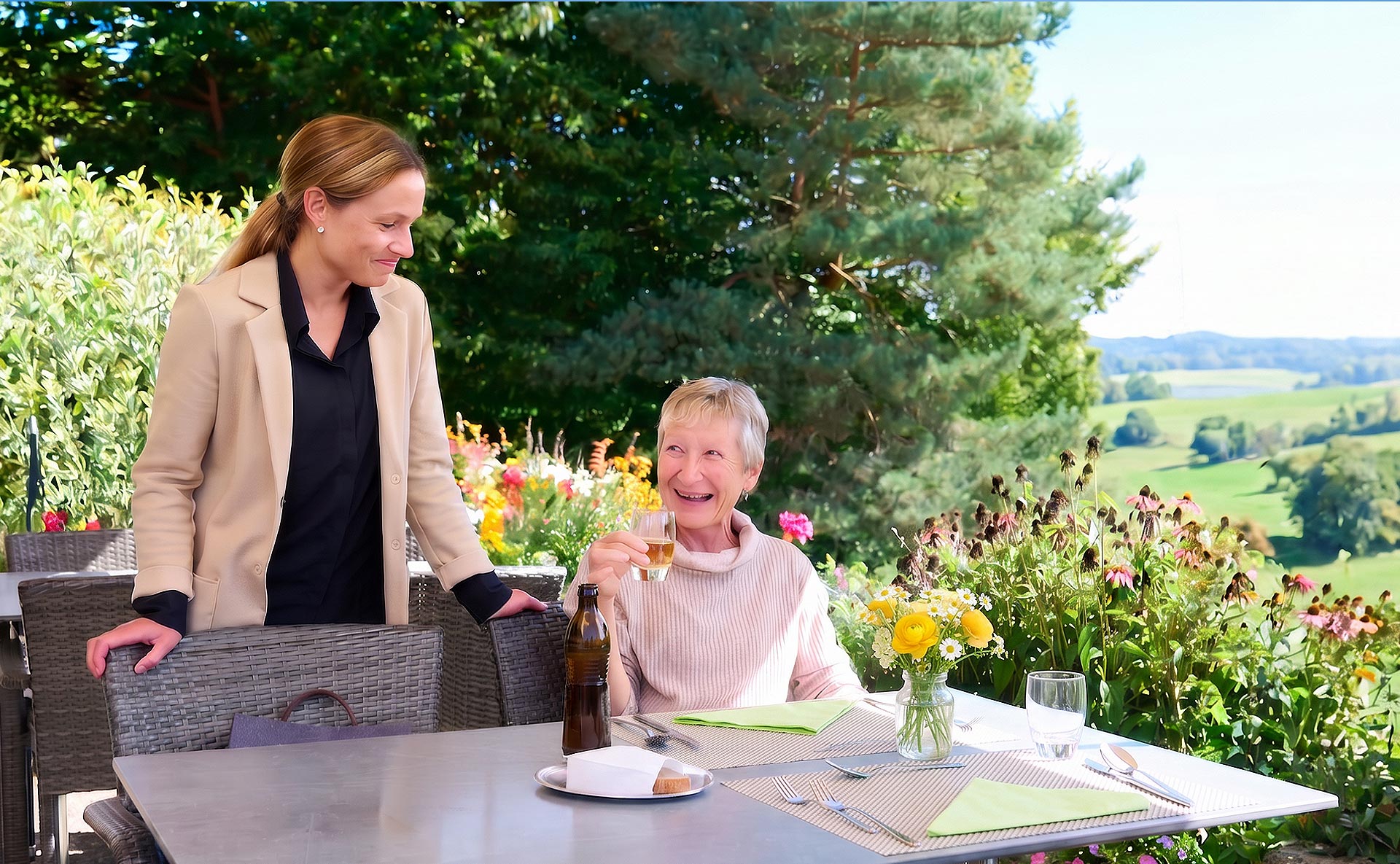 Gastronomie am Landhaus Neuenegg Ein Gast trinkt ein Rivella auf der Terrasse und unterhält sich mit einer Mitarbeiterin