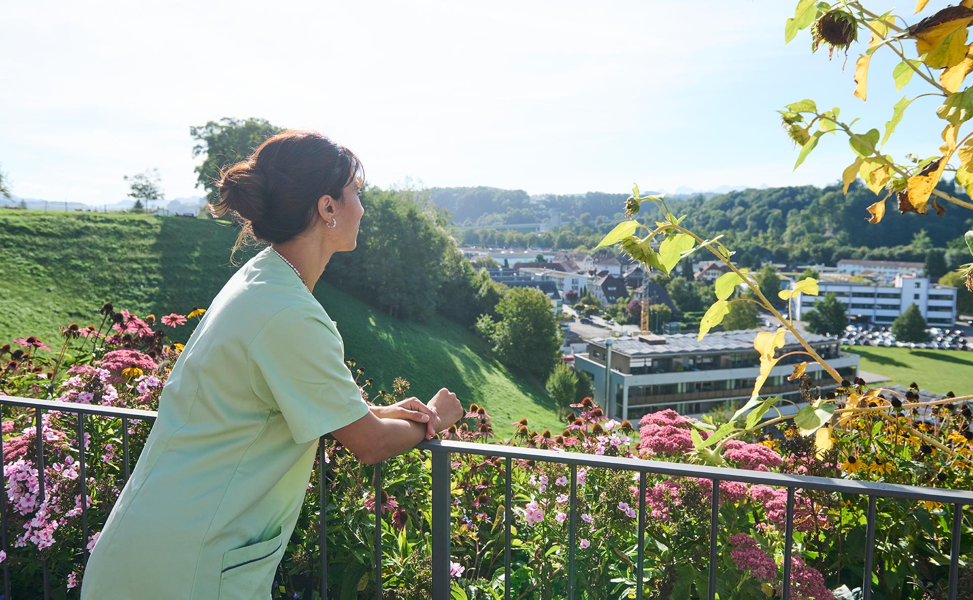 Arbeiten im Landhaus Neuenegg Eine Pflegerin steht auf der Terrasse des Landhaus Neuenegg und blickt in die Ferne