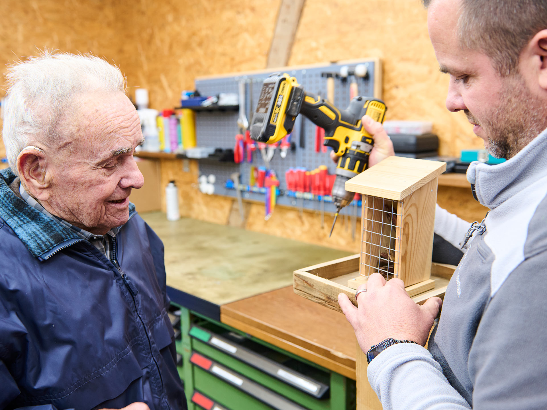 Aktivierung im Landhaus Neuenegg Ein Bewohner baut unter Anleitung in der Werkstatt ein Vogelhaus aus Holz.