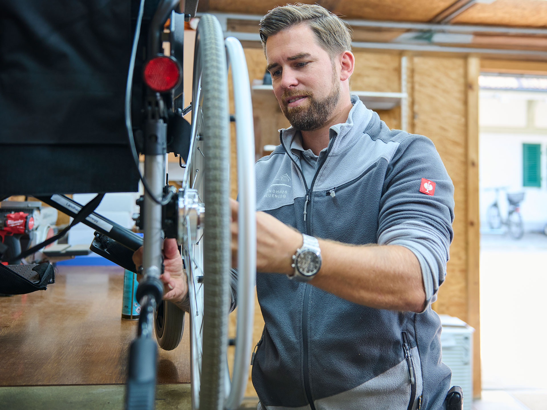 Ein Mitarbeiter repariert einen Rollstuhl