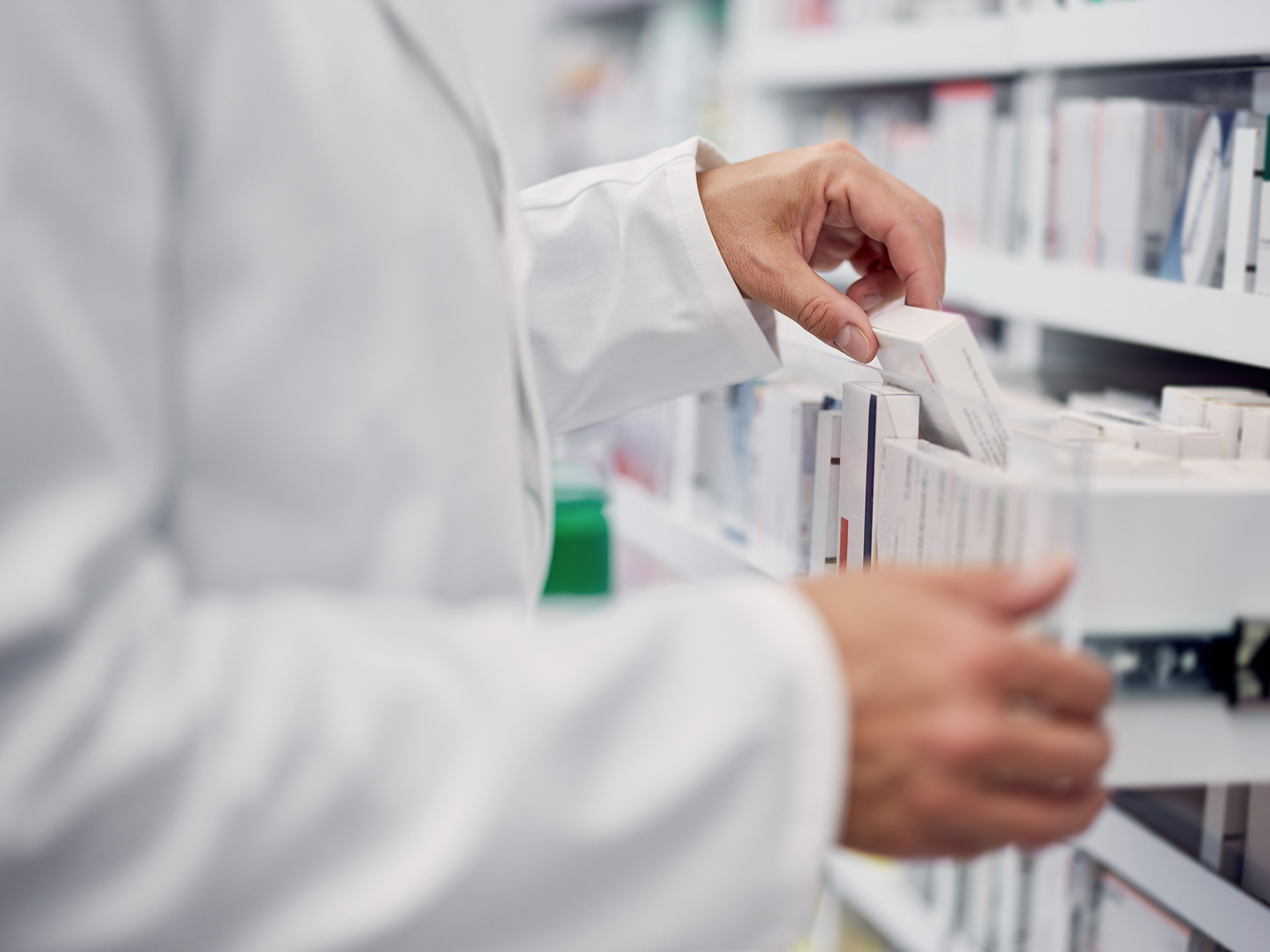 Apotheke Ein Apotheker steht an einem Regal mit Medikamenten